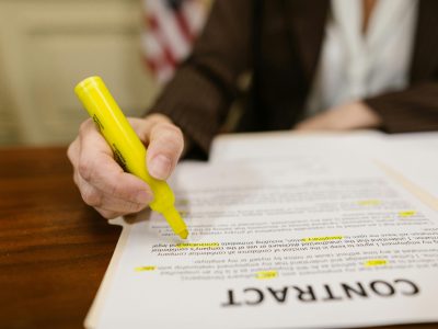 A close-up of a hand highlighting a contract, emphasizing important legal terms.